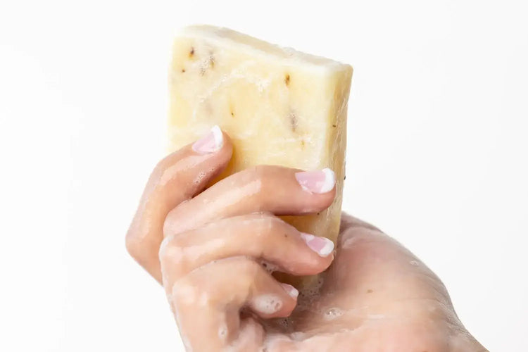 Hand holding a natural lemongrass soap bar with a refreshing finish, perfect for vegan skincare.
