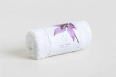 White rolled face towel with lavender flower design, part of the Lavender Luxury Gift Box for self-care.