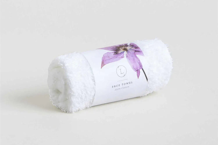 White rolled face towel with lavender flower design, part of the Lavender Luxury Gift Box for self-care.