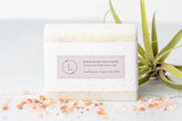 Himalayan salt soap bar with label, surrounded by pink salt and air plant, 100% natural and vegan.