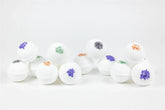 Lavender bath bombs with colorful flower accents arranged artistically for a calming self-care experience.
