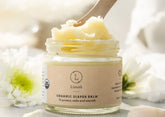 Organic diaper balm in a jar with a wooden scoop, designed to protect and nourish baby&
