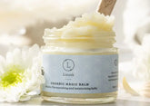 Organic Magic Balm in a glass jar with floral accents, perfect for nourishing and moisturizing skin.