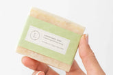 Handmade natural lemongrass soap bar, vegan and moisturizing, held in a hand with eco-friendly packaging.