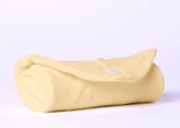 Rolled organic cotton baby blanket in soft yellow color, perfect for newborn care and comfort.